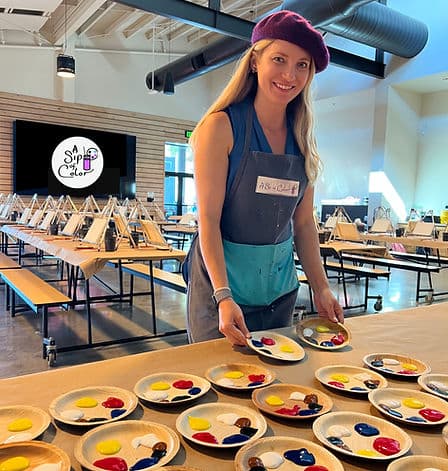 A Sip of Color host preparing paint palettes