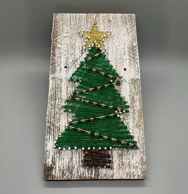 Colorful string art wrapped into a design on wood